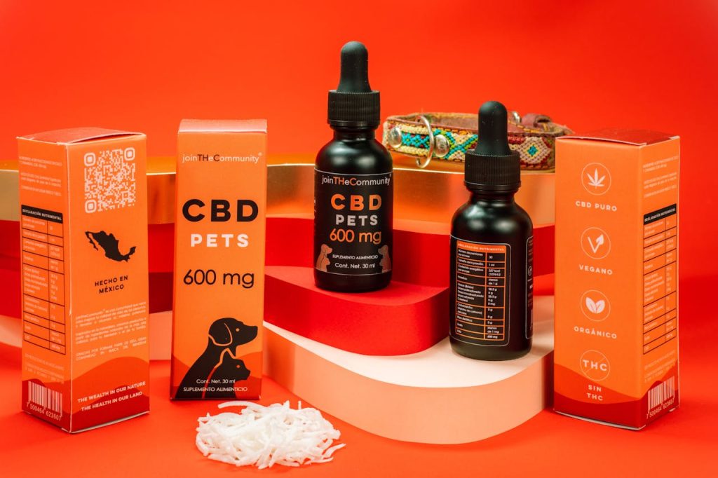 CBD pet product display with colorful packaging and a bold red backdrop.